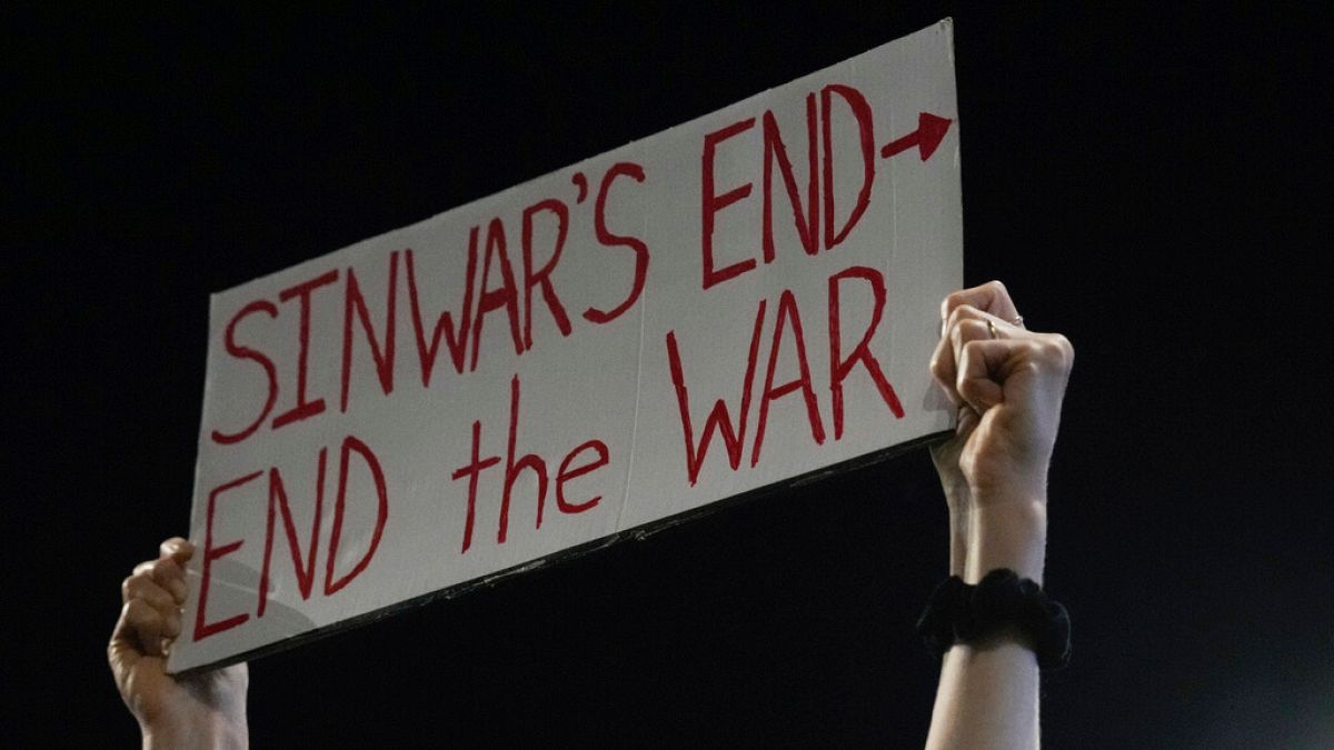 A demonstrator holds a sign about the killing of Hamas leader Yahya Sinwar during a protest calling for a cease-fire deal, Thursday, Oct. 17, 2024, in Tel Aviv, Israel.