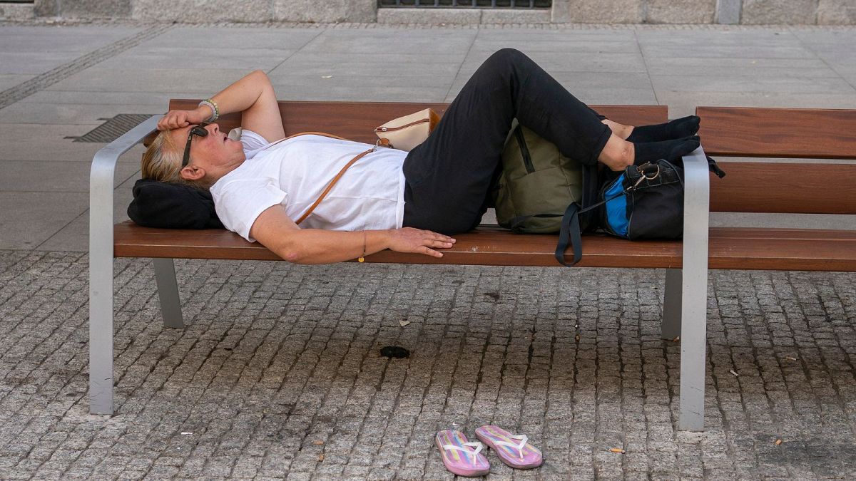 A woman lies on a bench during a heatwave in Madrid, Spain, August 2021.