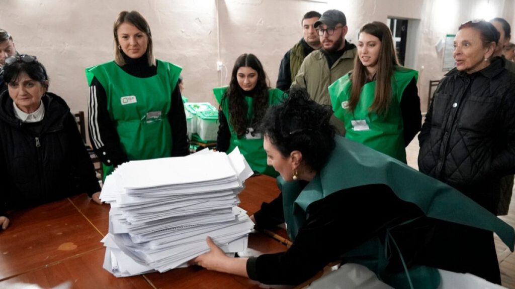 Members of an election commission prepare to count ballots at a polling station after the parliamentary election in Tbilisi, Georgia, Saturday, Oct. 26, 2024.