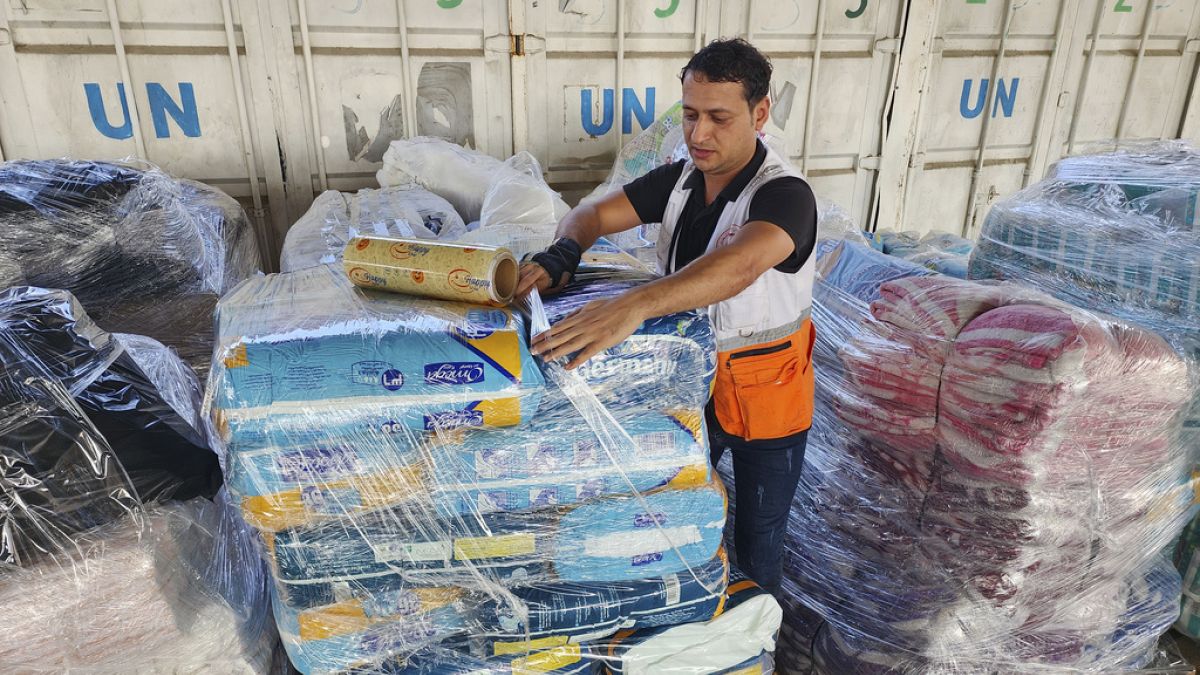 FILE - United Nations and Red Crescent workers prepare the aid for distribution to Palestinians at the UNRWA warehouse in Deir Al-Balah, Gaza Strip, on Monday, Oct. 23, 2023.