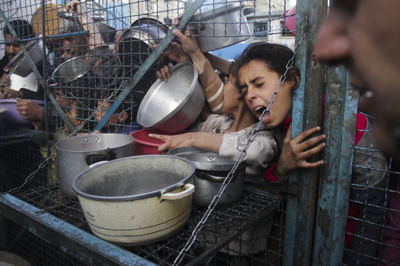 DOSSIER – Des Palestiniens font la queue pour recevoir des repas au camp de réfugiés de Jabaliya, dans la bande de Gaza, le 18 mars 2024. 