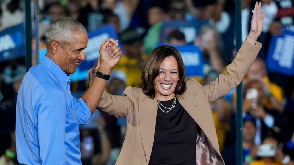 Former President Barack Obama holds hands with Democratic presidential nominee Vice President Kamala Harris after introducing her at a rally.