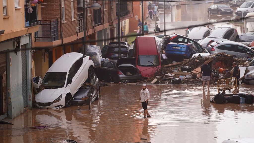 Residents look at cars piled up after being swept away by floods in Valencia, Spain, Wednesday, Oct. 30, 2024.