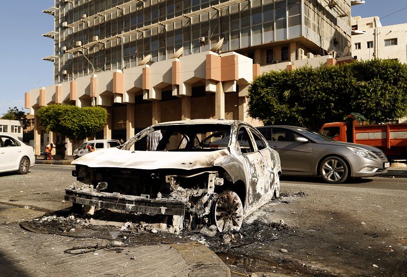 Les restes d'une voiture dans une rue de Tripoli, la capitale libyenne, après des affrontements entre milices rivales, le 28 août 2022