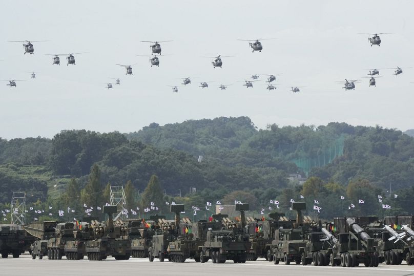 Des hélicoptères militaires sud-coréens survolent des véhicules blindés lors de la journée des médias pour le 76e anniversaire de la Journée des forces armées à la base aérienne de Séoul à Seongnam, le 25 septembre 2024.