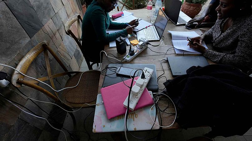 Les clients d'un restaurant travaillent sur des ordinateurs portables et chargent des appareils au Mercato Café à Lusaka, en Zambie, le mardi 17 septembre 2024.