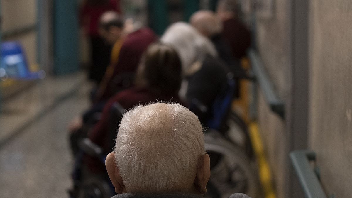 Elderly people wait in a line in Rome.