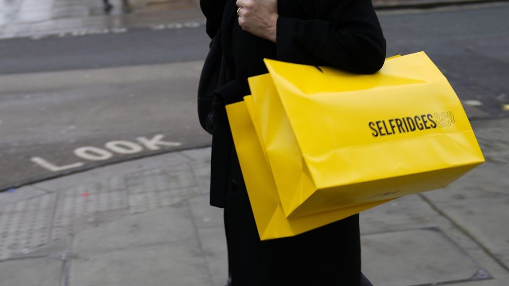 A woman carries a shopping bag from the London department store