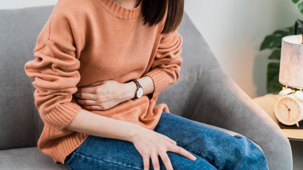 A woman experiences stomach pain.