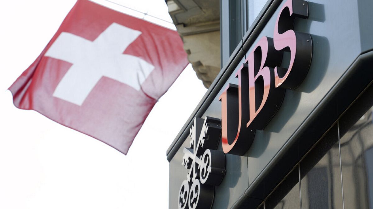 In this April 24, 2014 file photo a Swiss flag flutters beside the logo of UBS bank in Zurich, Switzerland.