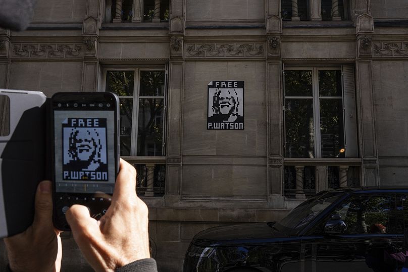 Une femme tient une pancarte à Paris alors qu'elle proteste pour exiger la libération du militant Paul Watson qui a été arrêté au Groenland en juillet et a demandé au président français Emmanuel Macron.