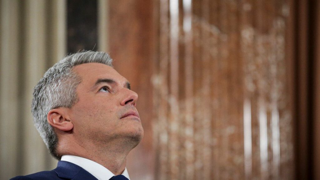 Austrian Chancellor Karl Nehammer looks up while attending a debate at the national broadcaster studio, set up in the parliament building, in Vienna, Austria, Sunday, Sept. 29