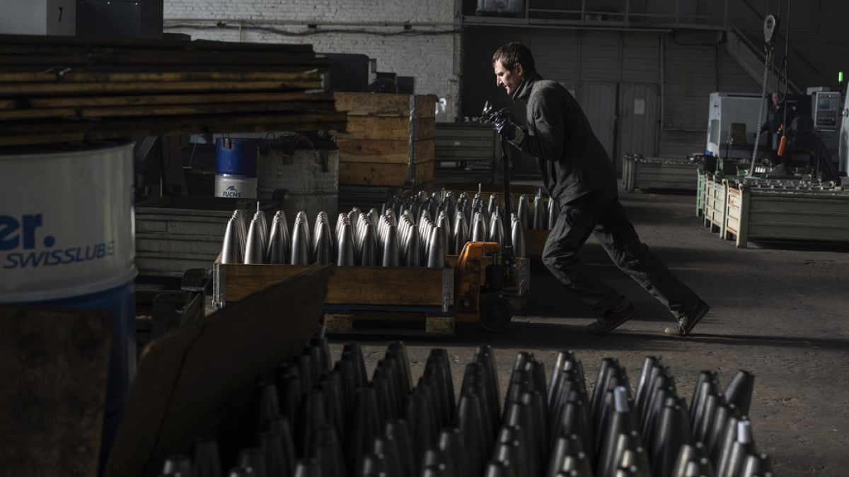 A worker hauls a cart with mortar shells at a factory in Ukraine