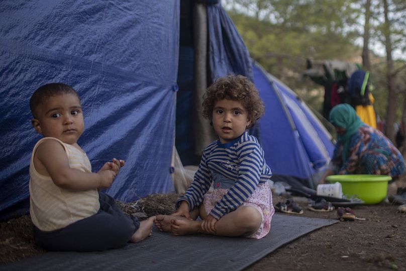 Des enfants syriens jouent devant une tente de fortune près du camp de réfugiés et de migrants sur l’île grecque de Samos.