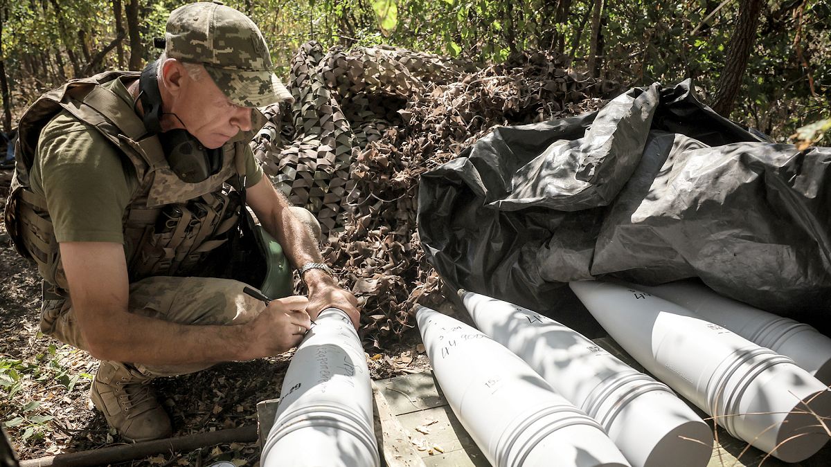 A soldier of the 24th Mechanised Brigade writes a massage on a 152mm self-propelled howitzer prior to firing towards Russian positions near Chasiv Yar, 20 August 2024