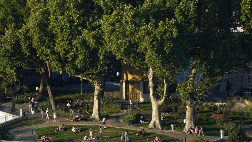 People enjoy a summer evening outdoors at a public garden in Lisbon in 2022.