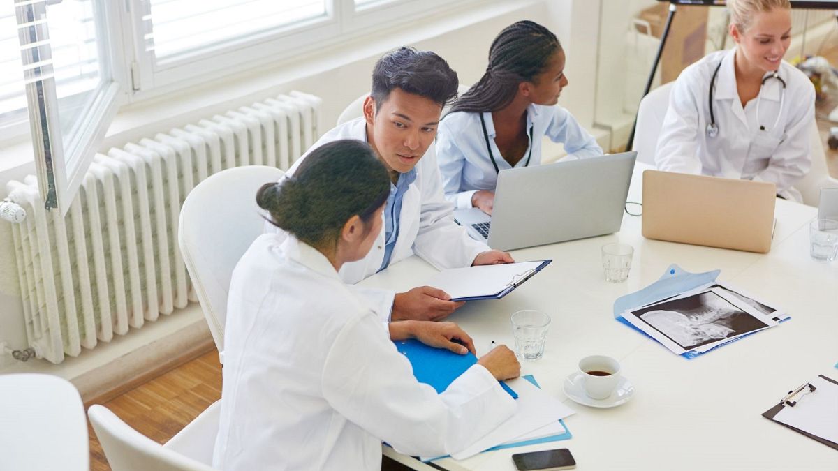 Medical students discuss around a table.