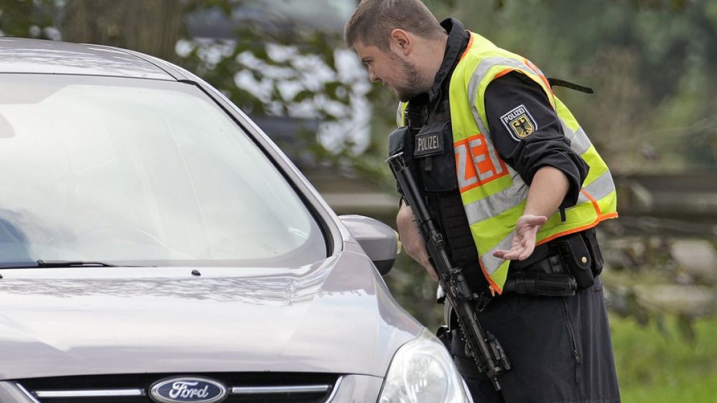 German police officer checks the details of the driver of a car near the border to Belgium in Aachen, Germany, Monday, Sept. 16, 2024