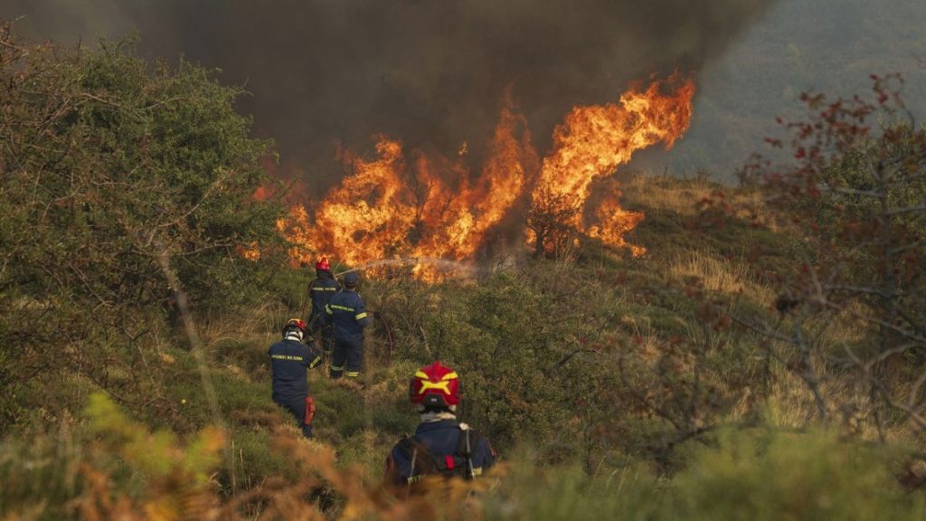 Firefighters try to extinguish the flames during a third day of a wildfire, in Sofiana village, about 142 kilometers (88 miles) west of Athens, Greece, on Tuesday, Oct. 1,