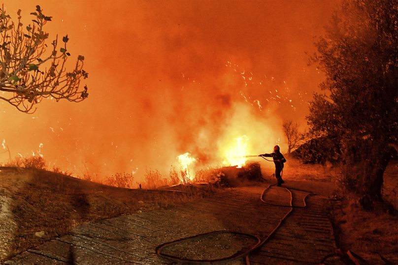 Un pompier tente d'éteindre les flammes près du village grec de Kallithea en septembre