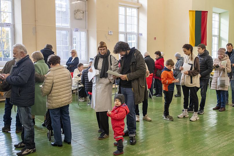 Des gens font la queue pour voter dans un bureau de vote lors du premier tour des élections législatives à Vilnius, le 13 octobre 2024.