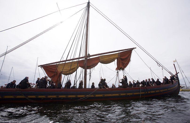 DOSSIER - Les membres de l'équipage hissent la voile d'un long navire viking depuis le fjord de Roskilde, au Danemark, le dimanche 1er juillet 2007. 