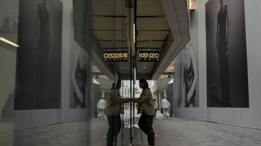 A man walks into a fashion boutique as shoppers tour at an outdoor shopping mall in Beijing, Thursday, Oct. 31, 2024