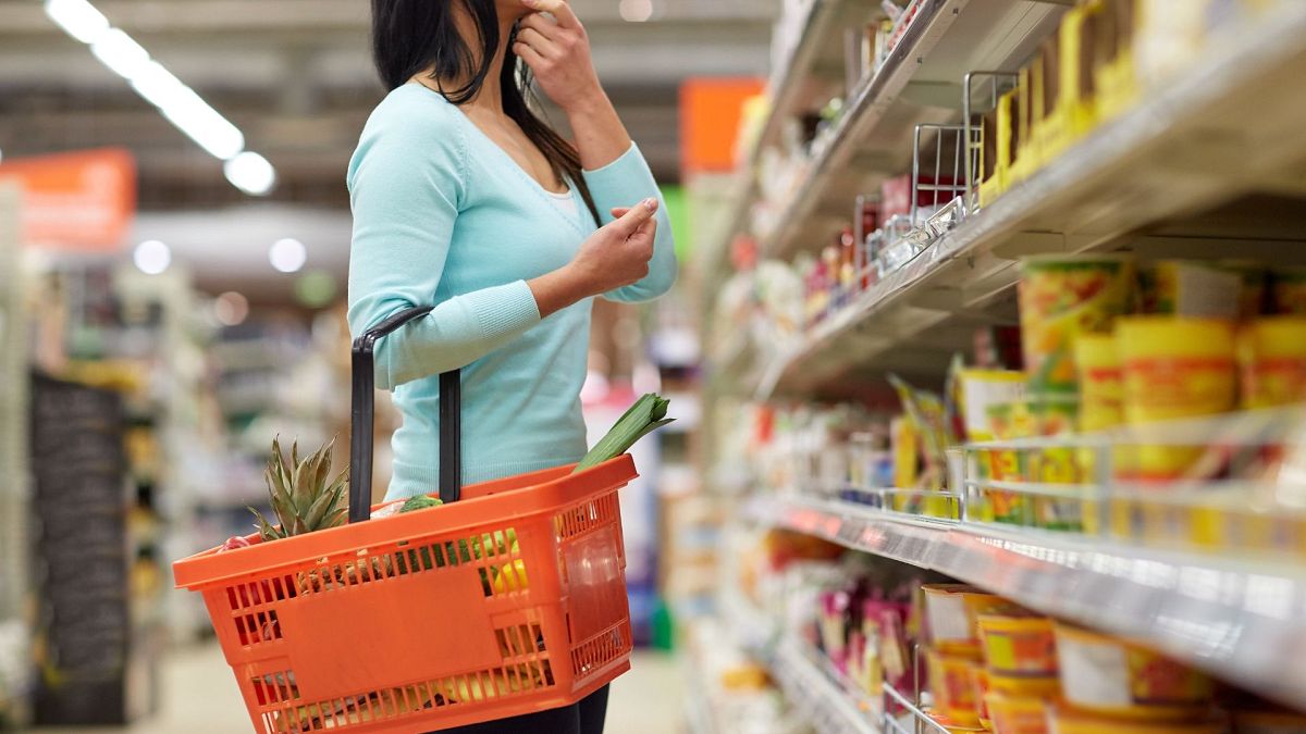 A woman with a shopping basket in a supermarket