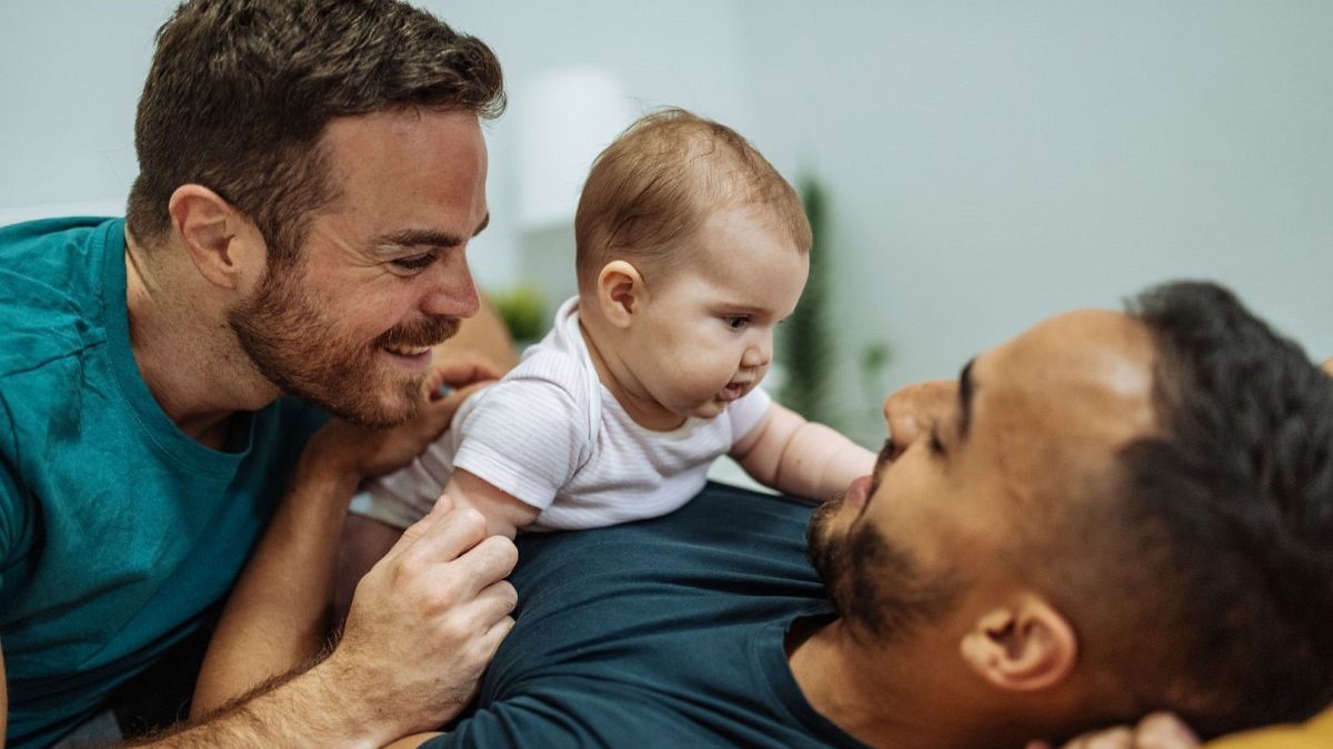 A couple plays with their baby.