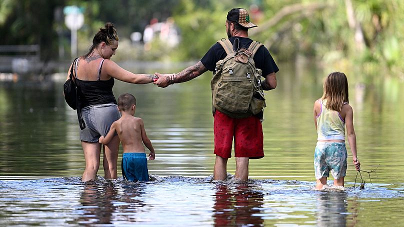 Dustin Holmes, Hailey Morgan et ses enfants retournent dans leur maison inondée à la suite de l'ouragan Helene, le 27 septembre 2024, à Crystal River, en Floride. 