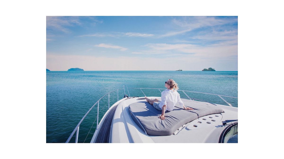 A woman sitting on the deck on a yacht