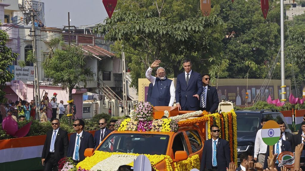 Indian Prime Minister Narendra Modi, center left, and his Spanish counterpart Pedro Sanchez, center right, wave to greet people from a vehicle in Vadodara, India. Oct28, 2024.