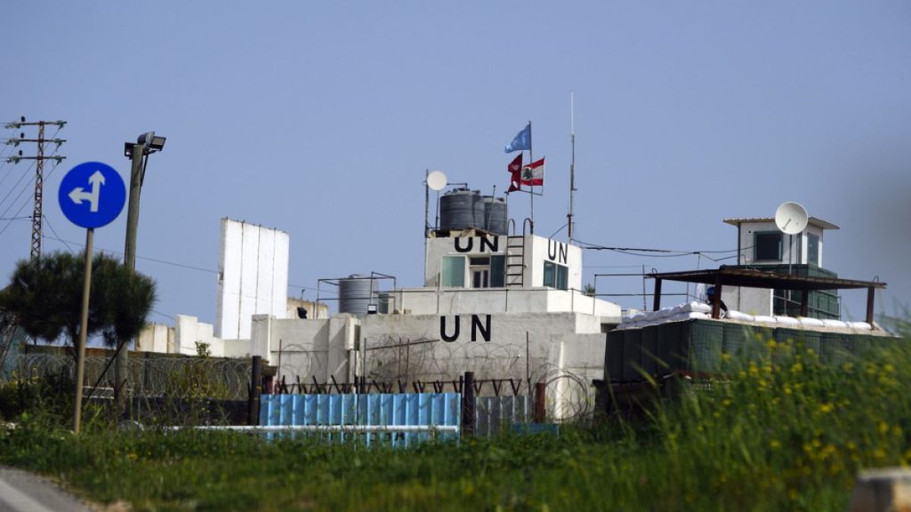 UN peacekeepers hold their flag, as they observe Israeli excavators attempt to destroy tunnels built by Hezbollah, near the southern Lebanese-Israeli border village of Mays