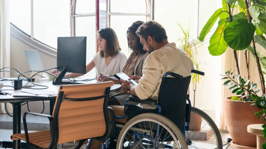 Team with a person with disability working in a office.