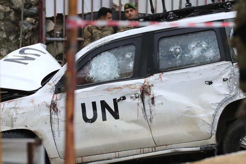 Des soldats libanais se tiennent derrière un véhicule endommagé après qu'un convoi de soldats de la paix de l'ONU ait essuyé des tirs dans le village d'Al-Aqbiya, au sud du Liban, le jeudi 15 décembre 2022. 