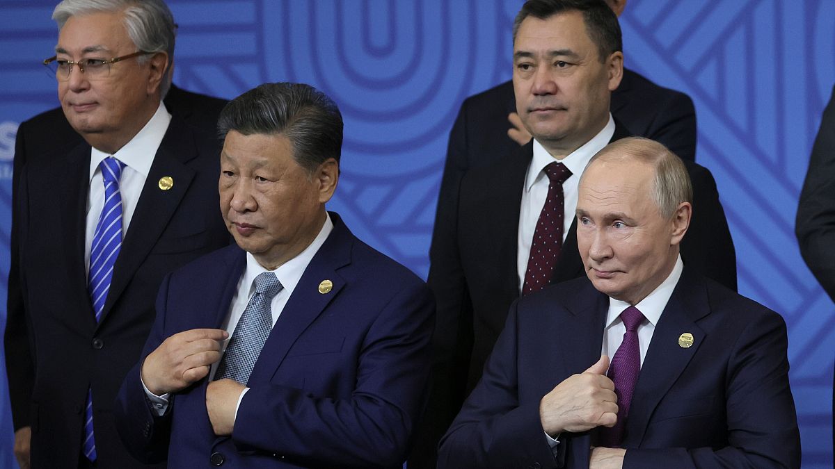 Chinese President Xi Jinping, left, and Russian President Vladimir Putin attend a family photo ceremony prior to Outreach/BRICS Plus format session at the BRICS Summit.