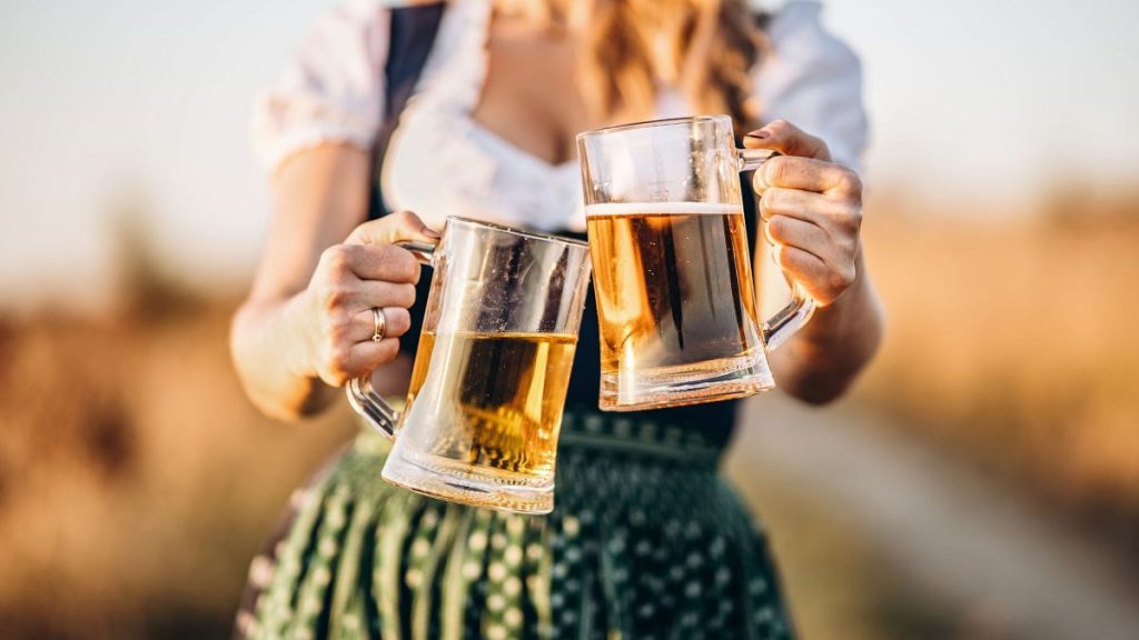 Woman in Dirndl Holding Glasses of Beer