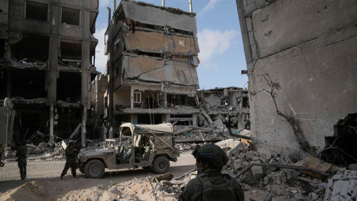 Israeli soldiers take up position next to destroyed buildings following Israeli strikes during a ground operation in the Gaza Strip on Friday, Sept. 13, 2024.