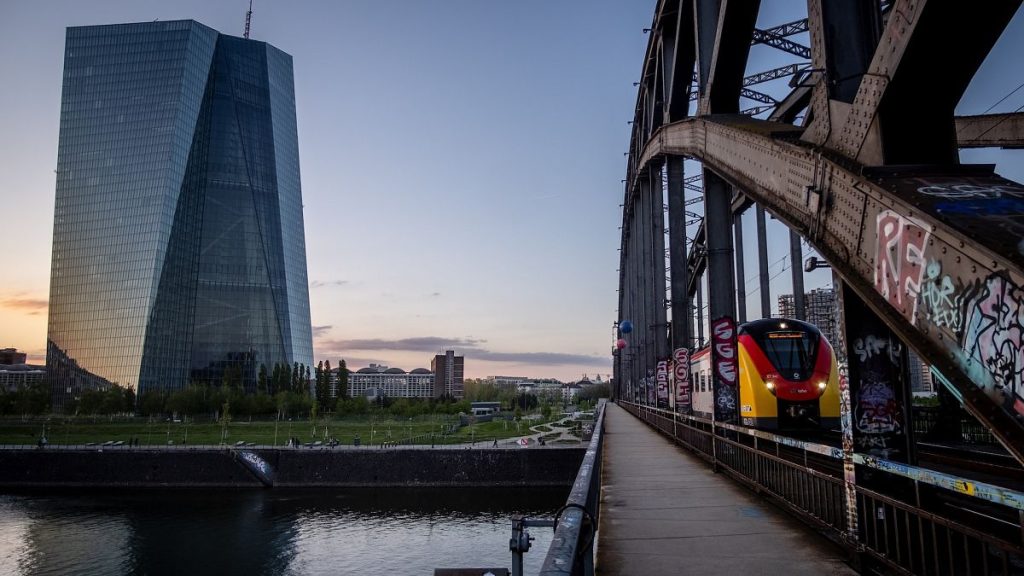 A train travels past the European Central Bank in Frankfurt, Germany