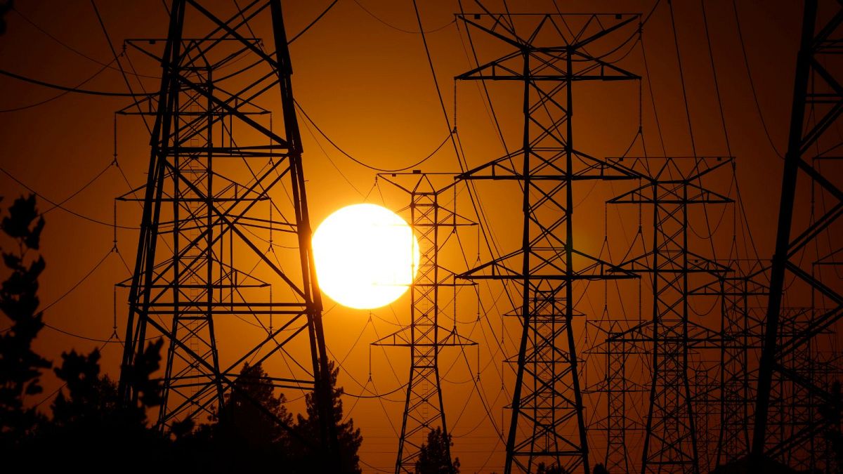 The sun sets behind high tension power lines in Los Angeles. September 2024.