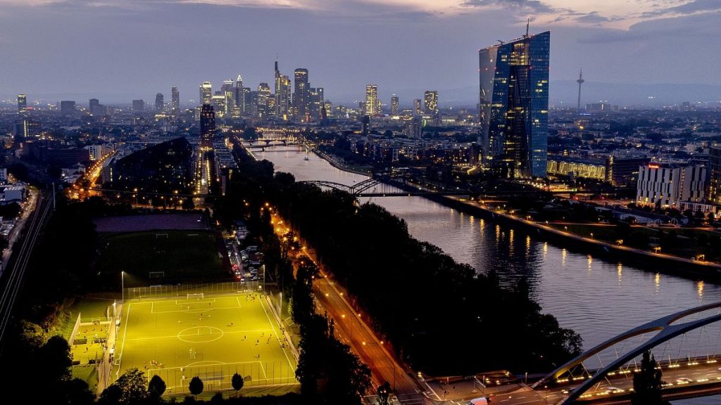 The European Central Bank stands at right as football players practise on a field next to the river Main, in Frankfurt.