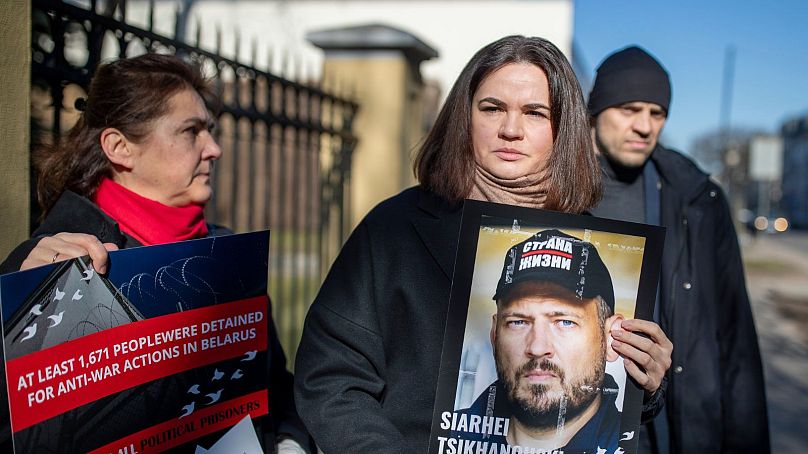 La chef de l'opposition biélorusse Sviatlana Tsikhanouskaya tient un portrait de son mari emprisonné, Siarhei Tsikhanouski, devant l'ambassade de Biélorussie, à Vilnius.