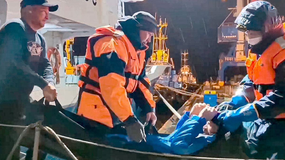 Russian emergency workers pull Mikhail Pichugin ashore after he was rescued by a fishing vessel following 67 days adrift in the Sea of Okhotsk, 15 October 2024