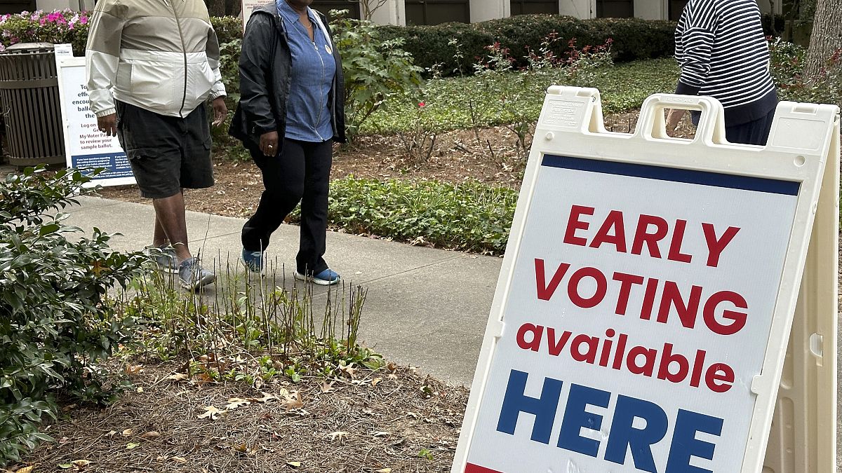 People leave after voting in the Atlanta suburb of Sandy Springs, Ga., on Tuesday, Oct. 15, 2024, the first day of early in-person voting in Georgia.