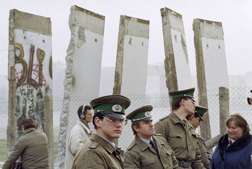 DOSSIER – Les gardes-frontières est-allemands se tiennent devant des segments du mur de Berlin, qui ont été retirés pour ouvrir le mur au passage de la Potsdamer Platz à Berlin, le 13 novembre 1989.