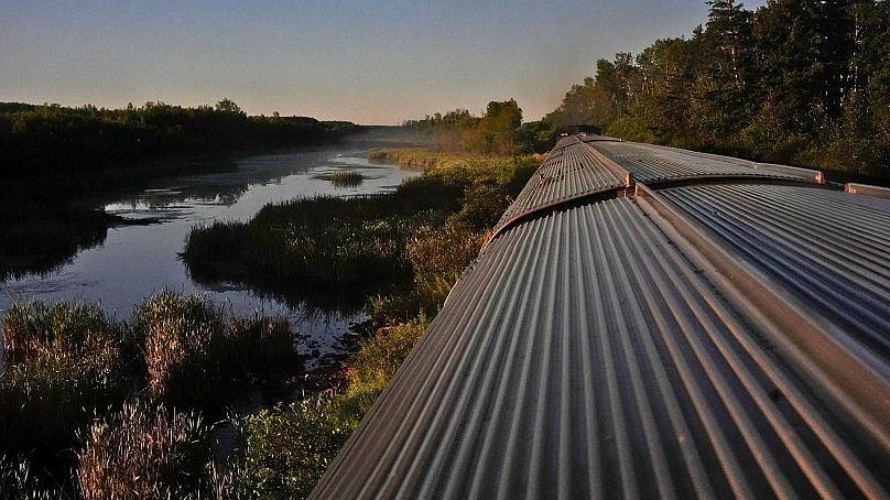 Un train traverse une nature sauvage isolée le samedi 10 août 2024, près de Canora, en Saskatchewan. 