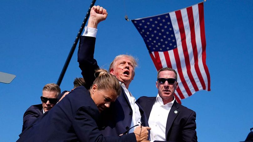 Donald Trump gestures after surviving an assassination attempt on stage at a campaign rally in in Butler, Pa.