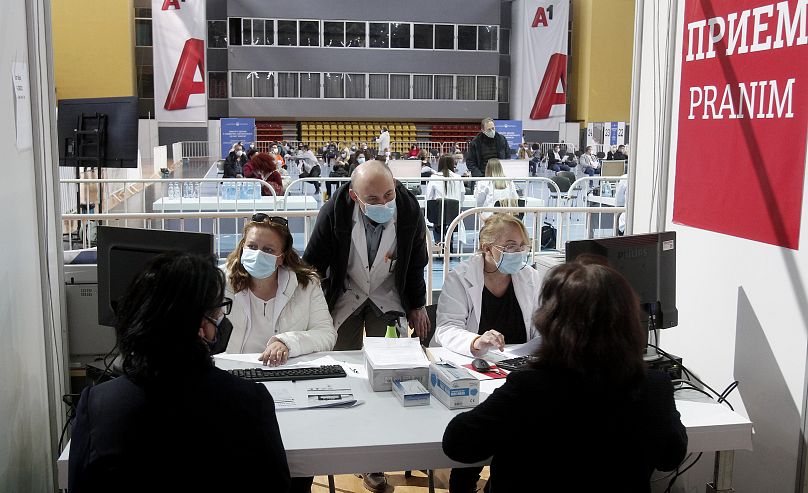 Des médecins et des agents de santé discutent avec des personnes avant leur vaccination au centre de vaccination de masse contre le COVID-19, à l'A1 Arena de Skopje, en Macédoine du Nord.