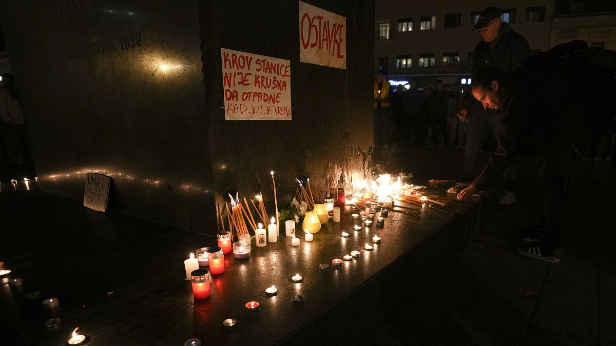 People light candles for the victims after an outdoor roof collapsed at a train station in Novi Sad, 1 November, 2024