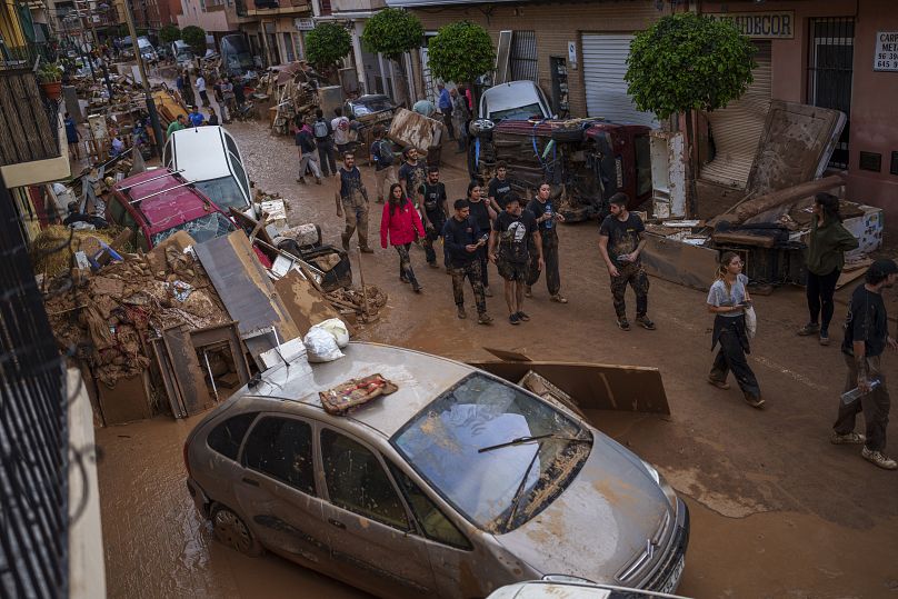 Des gens marchent dans une rue touchée par les inondations à Sedavi, le 1er novembre 2024